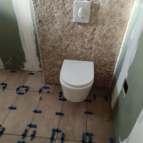 Rénovation complète de salle de bain avec pose WC suspendu et faïence pierre décorative
